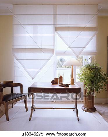 Table in front of window with white linen blinds in traditional living room View Large Photo Image Stock Photography - Table in front of window with white linen blinds in traditional living room. Fotosearch