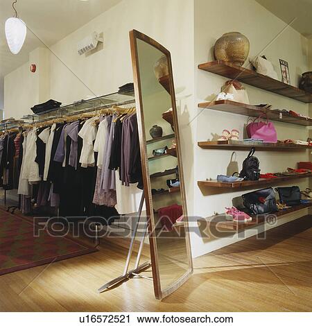 Tall freestanding mirror on wooden flooring in modern clothes shop with shoes and accessories on wooden shelving View Large Photo Image Stock Image - Tall freestanding mirror on wooden flooring in modern clothes shop with shoes and accessories on wooden shelving. Fotosearch