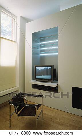 Stock Image - Television on shelf in modern white living room. Fotosearch