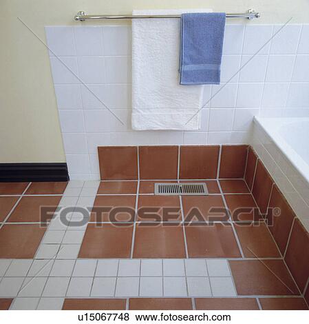 Terracotta and white tiled floor below towel rail in modern bathroom View Large Photo Image Stock Photo - Terracotta and white tiled floor below towel rail in modern bathroom. Fotosearch