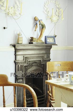 Thirties figurine on small Victorian iron fireplace in dining room View Large Photo Image Stock Image - Thirties figurine on small Victorian iron fireplace in dining room. Fotosearch