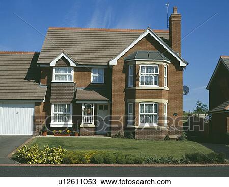 Stock Image - Traditional newbuild brick house on small estate. Fotosearch