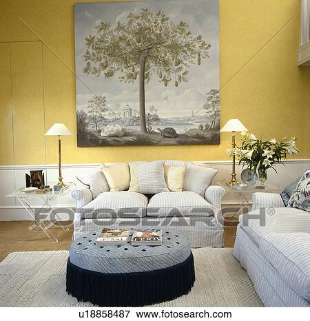 Traditional yellow living room with large picture above white sofa View Large Photo Image Stock Photo - Traditional yellow living room with large picture above white sofa. Fotosearch