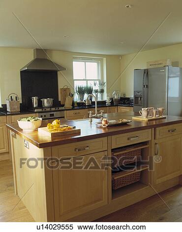 Tray and chopping board on large island unit with storage baskets in modern light wood country kitchen View Large Photo Image Stock Photography - Tray and chopping board on large island unit with storage baskets in modern light wood country kitchen. Fotosearch