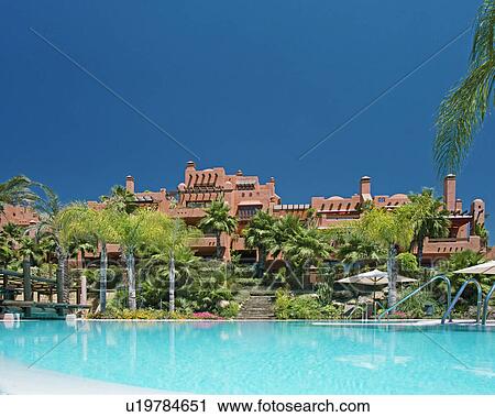Turquoise swimmingpool in front of terracotta newbuild Spanish holiday village View Large Photo Image Stock Image - Turquoise swimmingpool in front of terracotta newbuild Spanish holiday village. Fotosearch