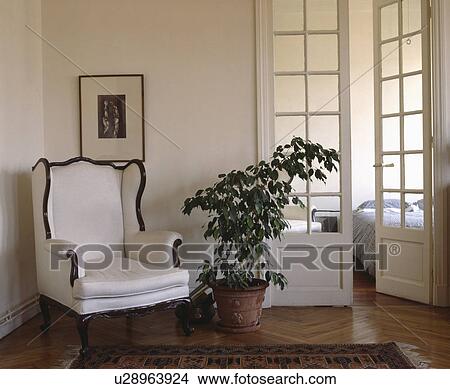 White armchair and houseplant in apartment hall with French doors View Large Photo Image Picture - White armchair and houseplant in apartment hall with French doors. Fotosearch