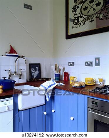 White ceramic Butler's sink built-in to bright blue fitted cupboards in traditional kitchen View Large Photo Image Stock Image - White ceramic Butler's sink built-in to bright blue fitted cupboards in traditional kitchen . Fotosearch