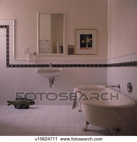 White clawfoot bath in white bathroom with white tiled wall and black border to dado height View Large Photo Image Stock Image - White clawfoot bath in white bathroom with white tiled wall and black border to dado height. Fotosearch