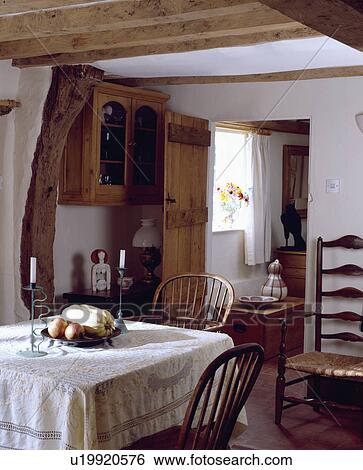 White cloth on table in small cottage dining room View Large Photo Image Stock Photograph - White cloth on table in small cottage dining room. Fotosearch