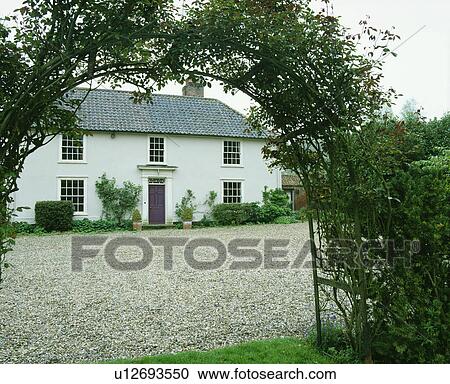 White exterior of detached country or suburban house with drive and rose arch in front. View Large Photo Image Stock Image - White exterior of detached country or suburban house with drive and rose arch in front.. Fotosearch