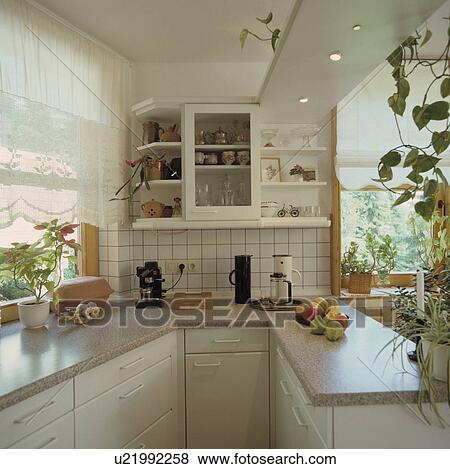 White lace blind on window in modern white galley kitchen with grey granite worktops View Large Photo Image Stock Photo - White lace blind on window in modern white galley kitchen with grey granite worktops. Fotosearch