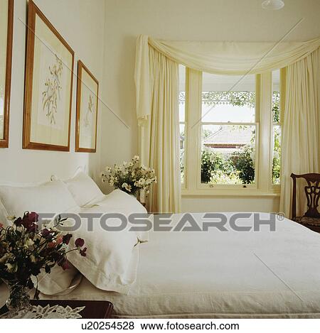 White pillows and quilt on bed in traditional white bedroom with white curtains at sash window View Large Photo Image Stock Photo - White pillows and quilt on bed in traditional white bedroom with white curtains at sash window. Fotosearch