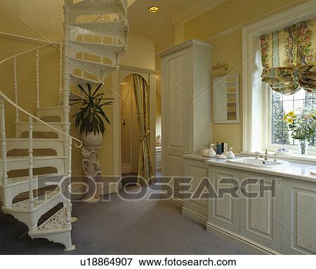 White spiral staircase in yellow eighties bathroom with festoon blind above fitted white vanity unit View Large Photo Image Stock Photo - White spiral staircase in yellow eighties bathroom with festoon blind above fitted white vanity unit. Fotosearch