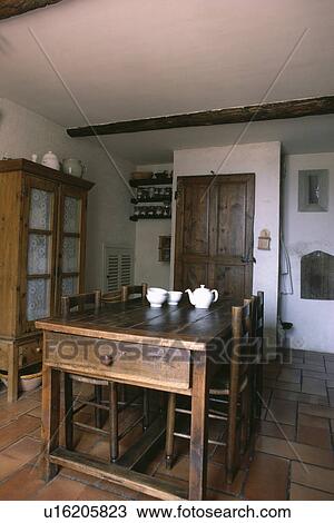 White teapot and bowls on antique wooden table with matching chairs in French country dining room View Large Photo Image Stock Image - White teapot and bowls on antique wooden table with matching chairs in French country dining room. Fotosearch