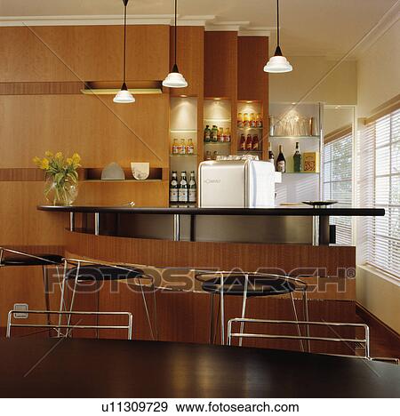 Stock Photo - Wooden breakfast bar with high stools and bar storage.. Fotosearch