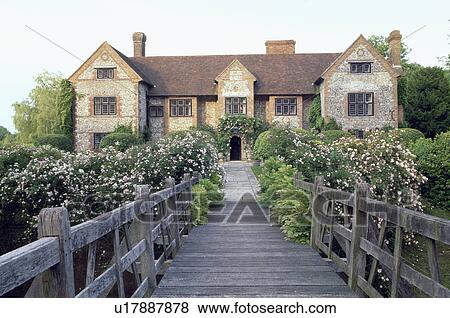 Wooden bridge and pink roses in front of large country house in summer View Large Photo Image Stock Photo - Wooden bridge and pink roses in front of large country house in summer. Fotosearch