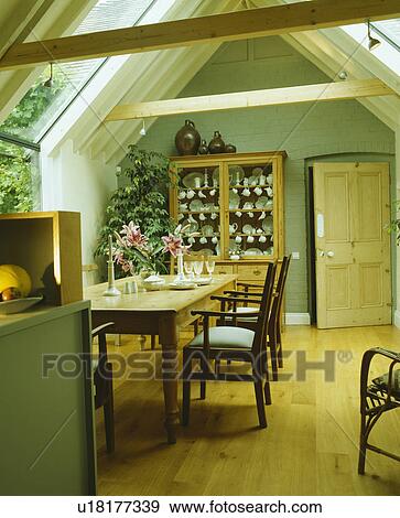 Wooden flooring in pastel green dining room extension with old pine table and apex ceiling View Large Photo Image Stock Photo - Wooden flooring in pastel green dining room extension with old pine table and apex ceiling. Fotosearch
