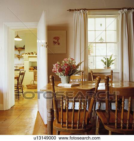 Wooden table and spindle-back chairs in coutnry dining room with cream curtains View Large Photo Image Stock Image - Wooden table and spindle-back chairs in coutnry dining room with cream curtains. Fotosearch