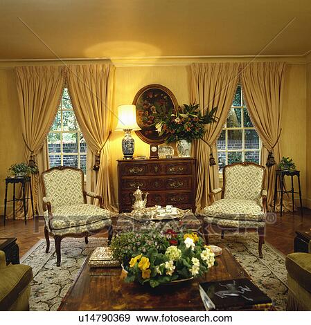 Yellow curtains and cream chairs in traditional yellow living room View Large Photo Image Stock Photo - Yellow curtains and cream chairs in traditional yellow living room. Fotosearch