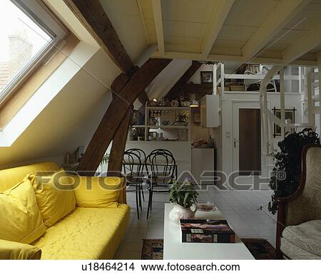 Picture - Yellow sofa below window in openplan living and dining room in attic conversion. Fotosearch
