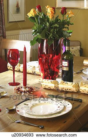 Yellow tulips in red glass vase on table with Christmas crackers beside place settings View Large Photo Image Stock Image - Yellow tulips in red glass vase on table with Christmas crackers beside place settings. Fotosearch