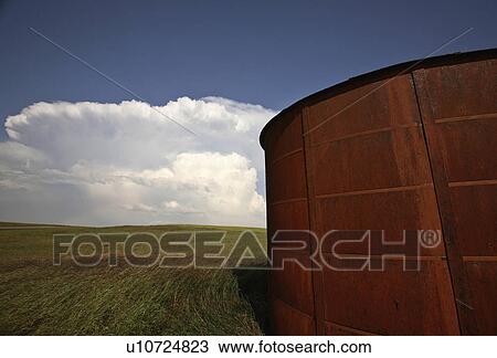 Stock Image -  background summer wooden granary clouds in storm . Fotosearch