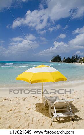 Stock Photo -  beach beautiful yellow umbrella chair in front. Fotosearch