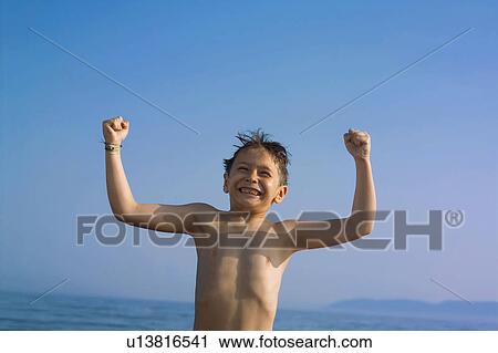 Stock Image -  beach child 7-9 years arms raised blue sky body. Fotosearch