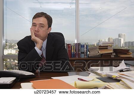 Stock Photo -  business office bored sitting desk in view city. Fotosearch