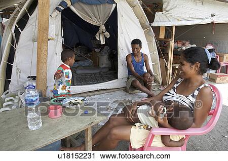 Stock Image -  family people timor leste in front tent camp for internally displaced. Fotosearch