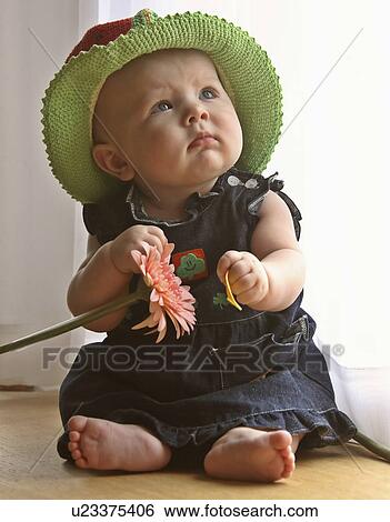 Stock Photograph -  flower baby child children fancy hat playing toy. Fotosearch