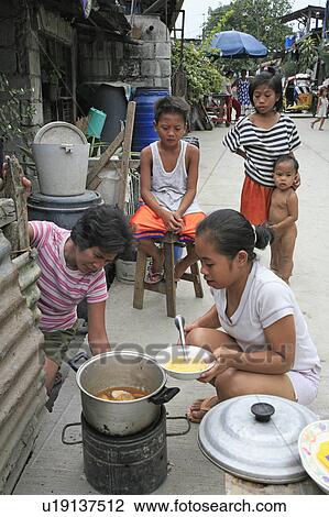 Stock Image -  food people person cooking front slum dwelling. Fotosearch