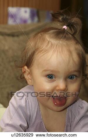 Stock Photo -  girl 7 month old toddler mr smiling tongue out . Fotosearch
