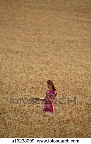 Stock Photo -  girl children redhead standing in wheat field . Fotosearch