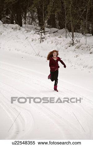 Stock Photography -  girl winter redheaded running down forest road. Fotosearch