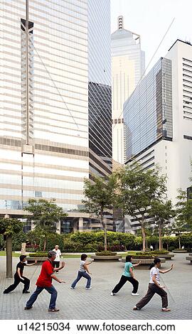 Picture -  group practicing tai chi in hong kong park china. Fotosearch