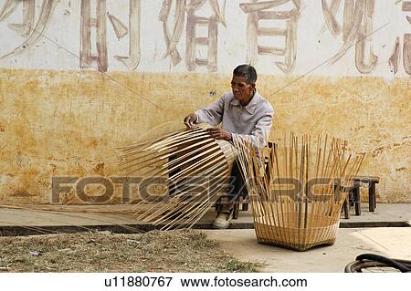 Stock Photo -  man art male weaving large baskets yulang river . Fotosearch
