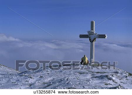 Picture -  man austria cross sitting mountain hill holiday. Fotosearch