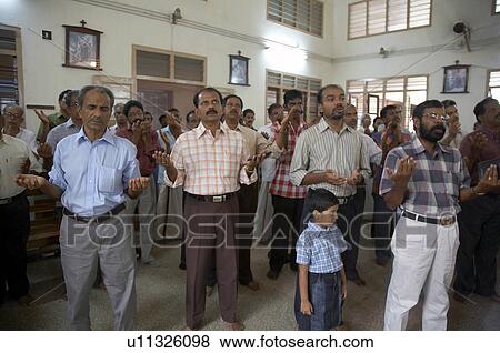 Stock Photo -  man india catholic parish sunday mass saint. Fotosearch