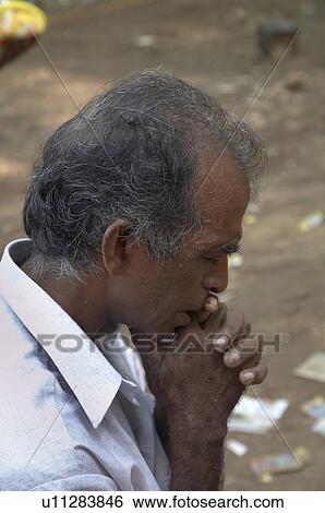 Stock Photograph -  man india praying station cross pilgrimage hill. Fotosearch