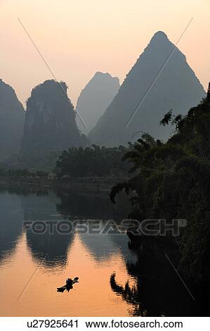 Stock Image -  man sun male paddles bamboo raft lijiang river . Fotosearch