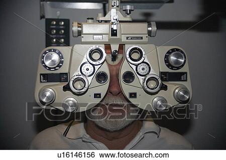 Stock Photograph -  medical man patient undergoing eye test use exam . Fotosearch