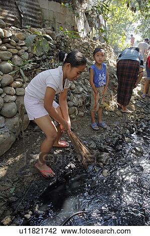 Stock Image -  people person cleaning up filthy polluted stream. Fotosearch