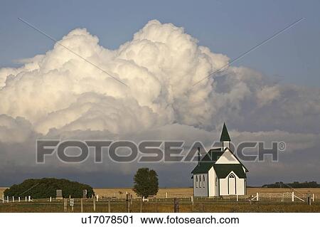 Stock Image -  summer clouds forming behind country church . Fotosearch