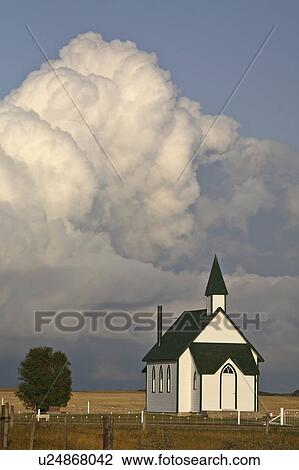 Stock Image -  summer clouds forming behind country church . Fotosearch