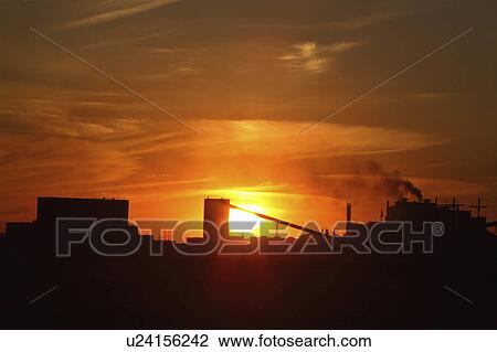 Stock Image -  sun art setting behind mosaic potash mine in sun . Fotosearch