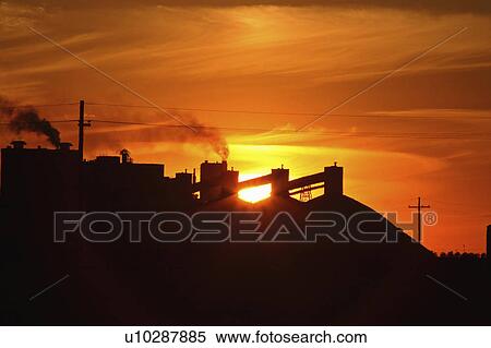 Stock Photography -  sun art setting behind mosaic potash mine in sun . Fotosearch