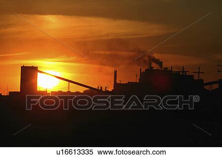 Stock Photography -  sun art setting behind mosaic potash mine in sun . Fotosearch