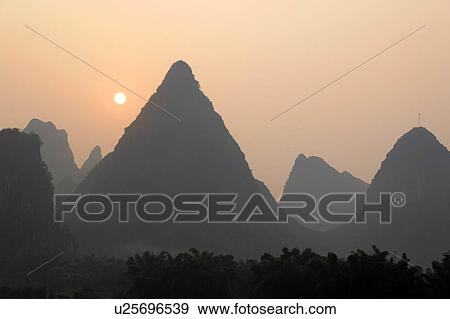 Stock Photo -  sun rising over karst mountains yangshuo guanxi . Fotosearch