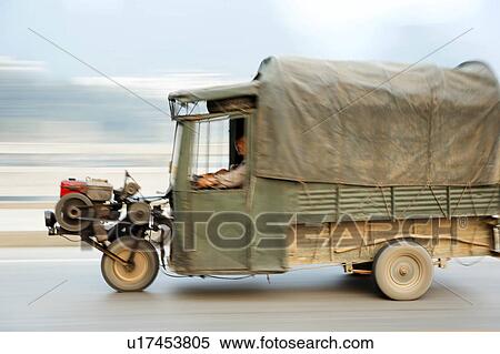 three wheeled tuk truck moving down road guanxi View Large Photo Image Stock Photography - three wheeled tuk truck moving down road guanxi. Fotosearch